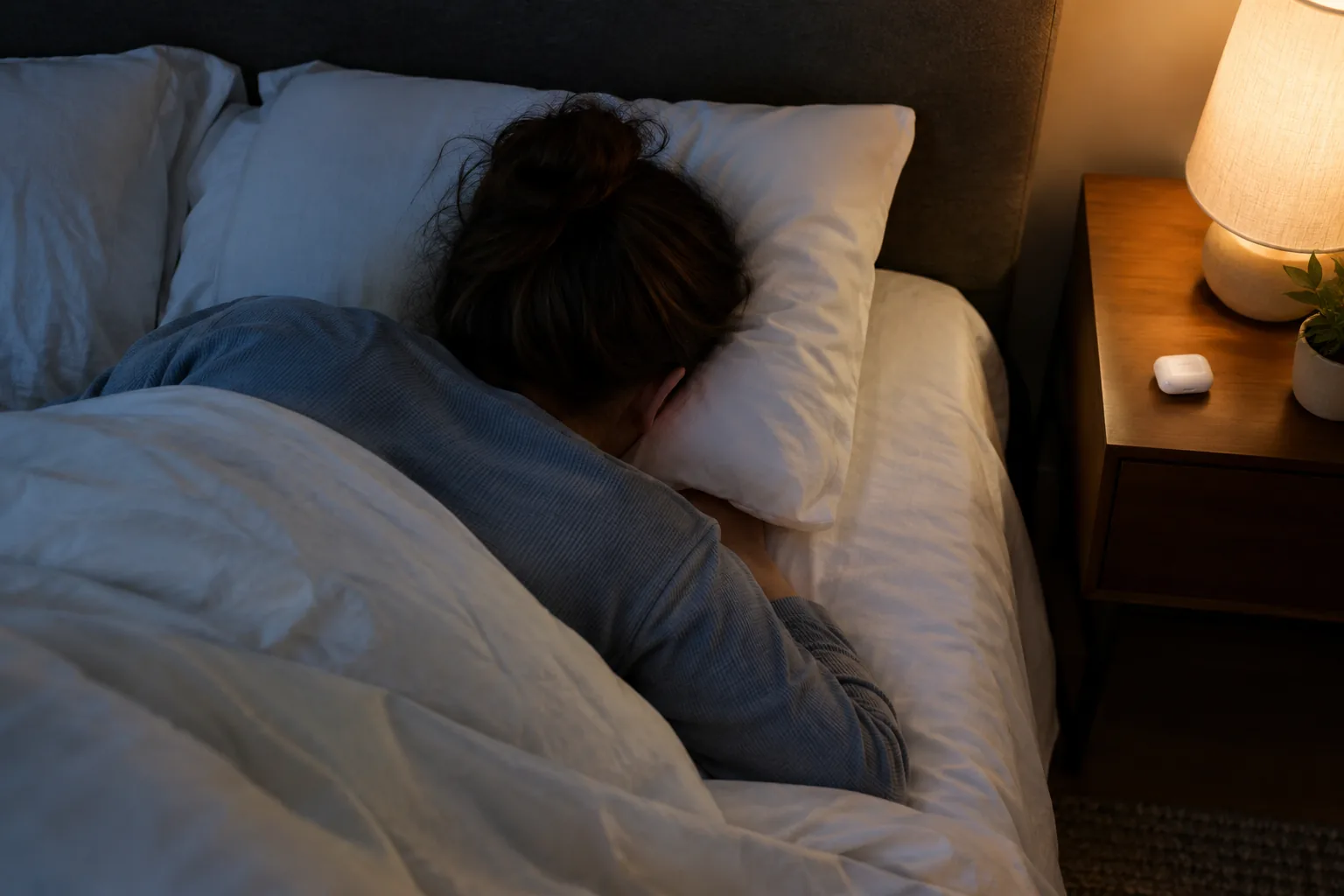 Side sleeper lying with an ear on the pillow, a setting for noise-canceling earbuds for sleep